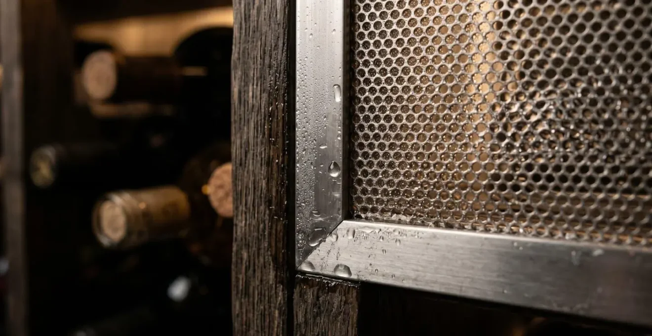 Détail macro d'un système de régulation d'humidité dans une cave à vin avec textures métalliques et bois