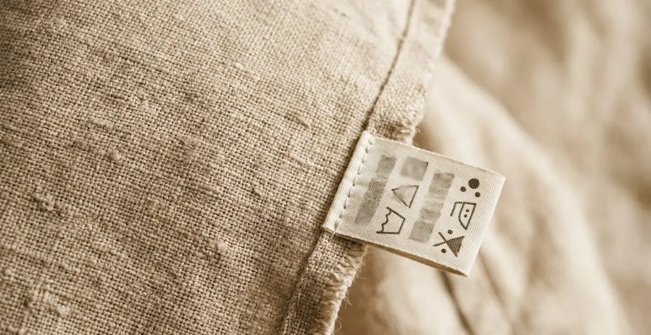 Gros plan sur une étiquette d'entretien de textile en lin avec symboles de lavage et mention de traitement