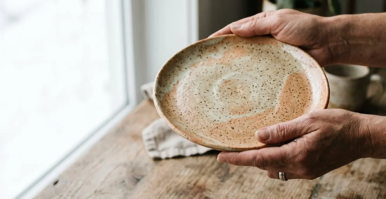 Assiette en grès avec finition mouchetée organique sur table en bois rustique